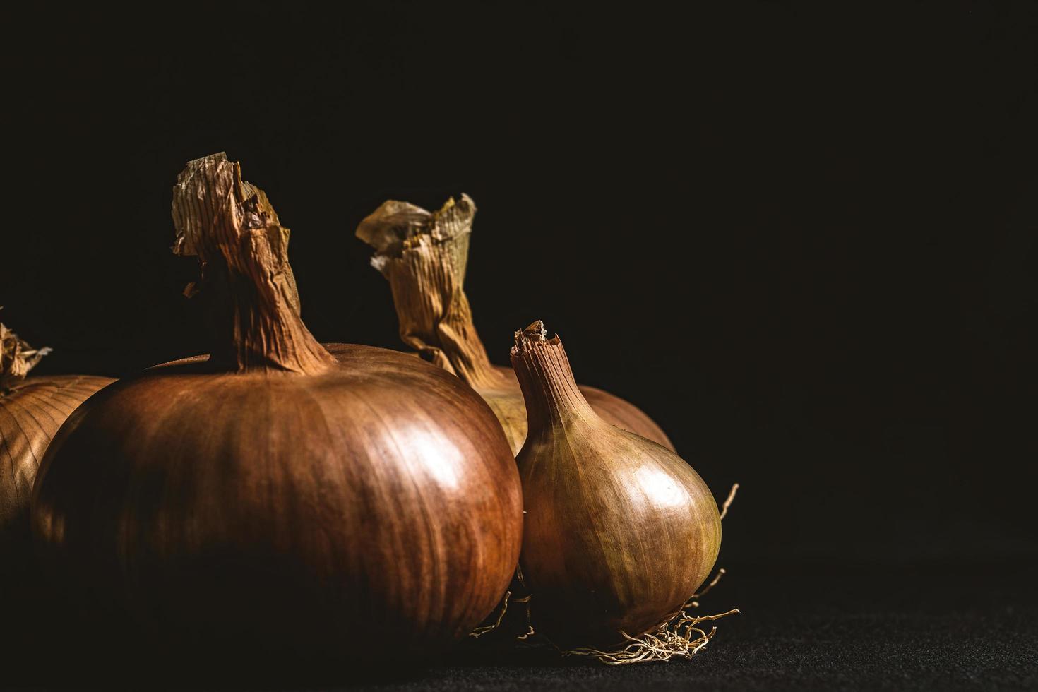 gele uien op een zwarte achtergrond foto