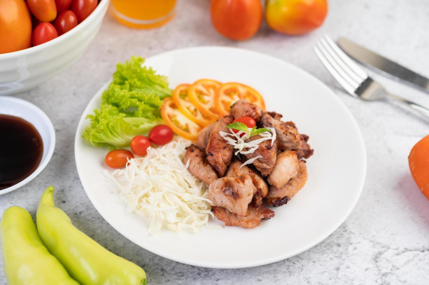 gegrilde varkenskotelet met tomaten en salade foto