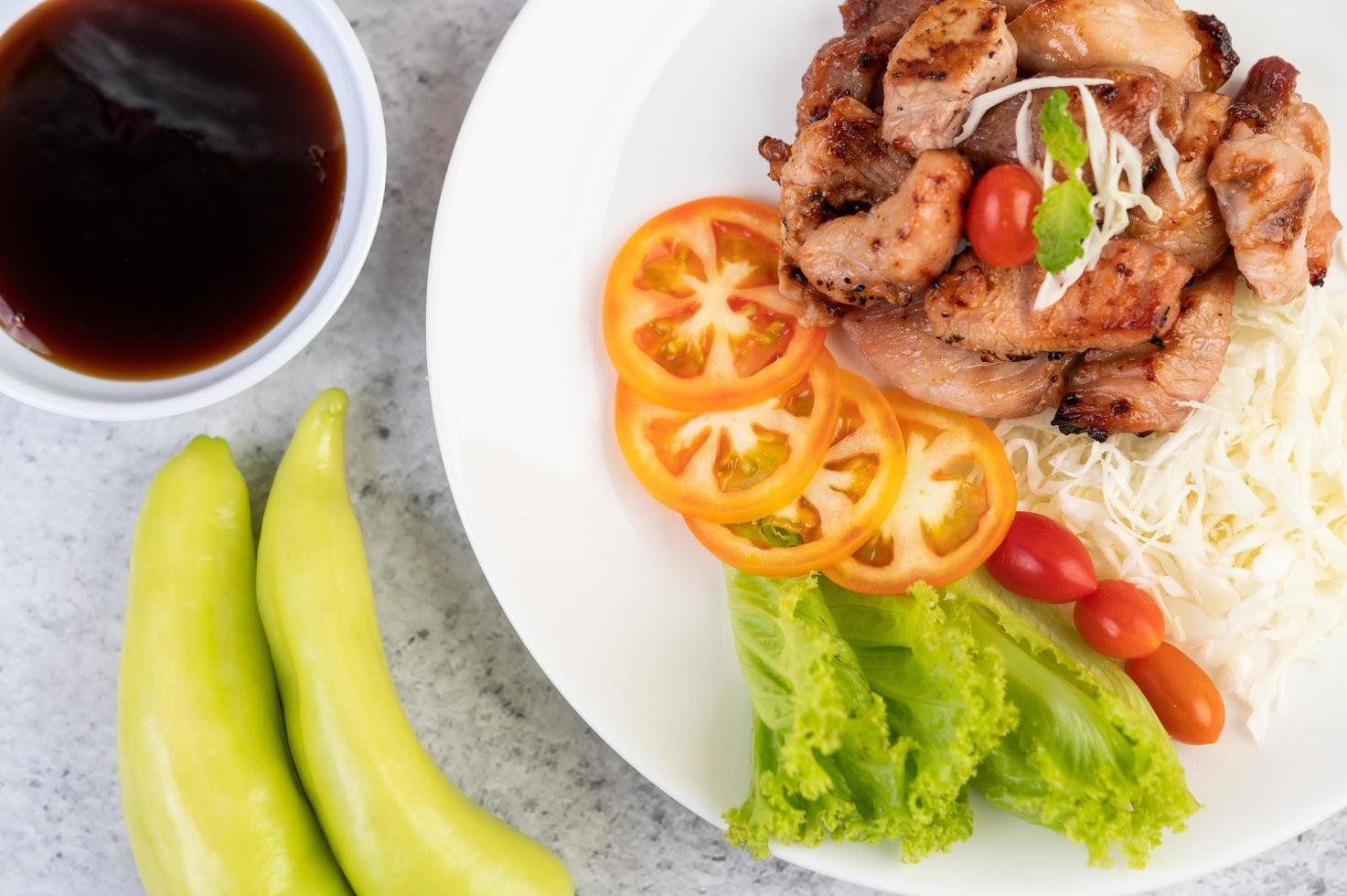 gegrilde varkenskotelet met tomaten en salade foto