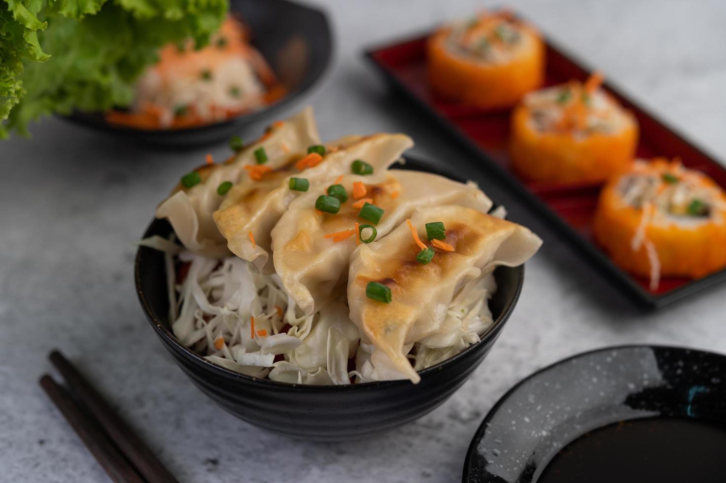 gyoza in een zwarte beker met saus foto