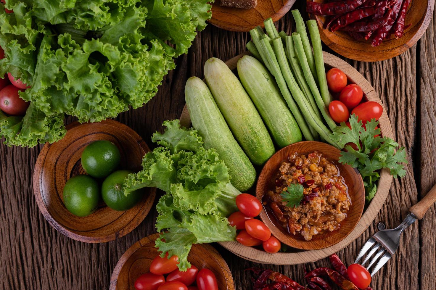 zoet varkensvlees in een houten kom met ingrediënten foto