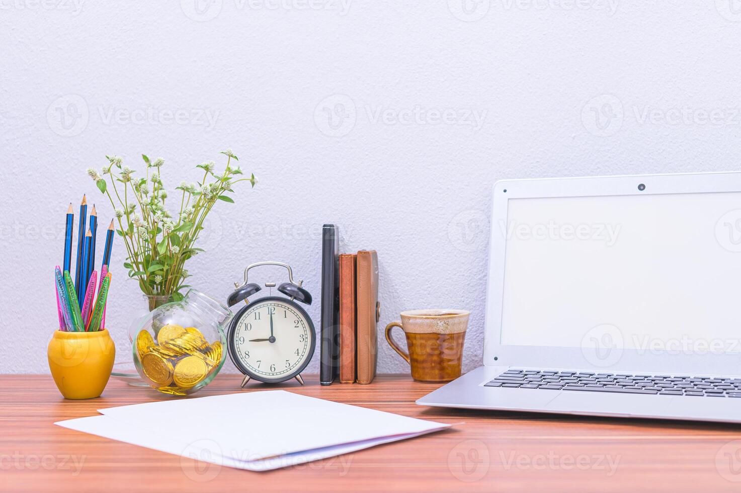 laptop, beker en bloem op het bureau foto