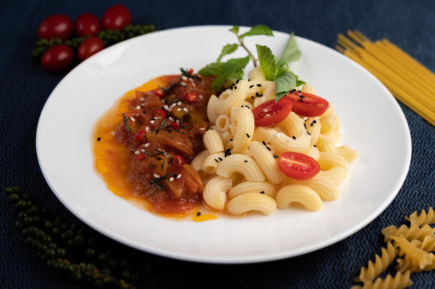 roergebakken macaroni met tomaat, chili, peperzaadjes en basilicum foto