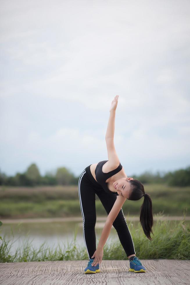 gezonde jonge vrouw buiten warming-up voor training foto