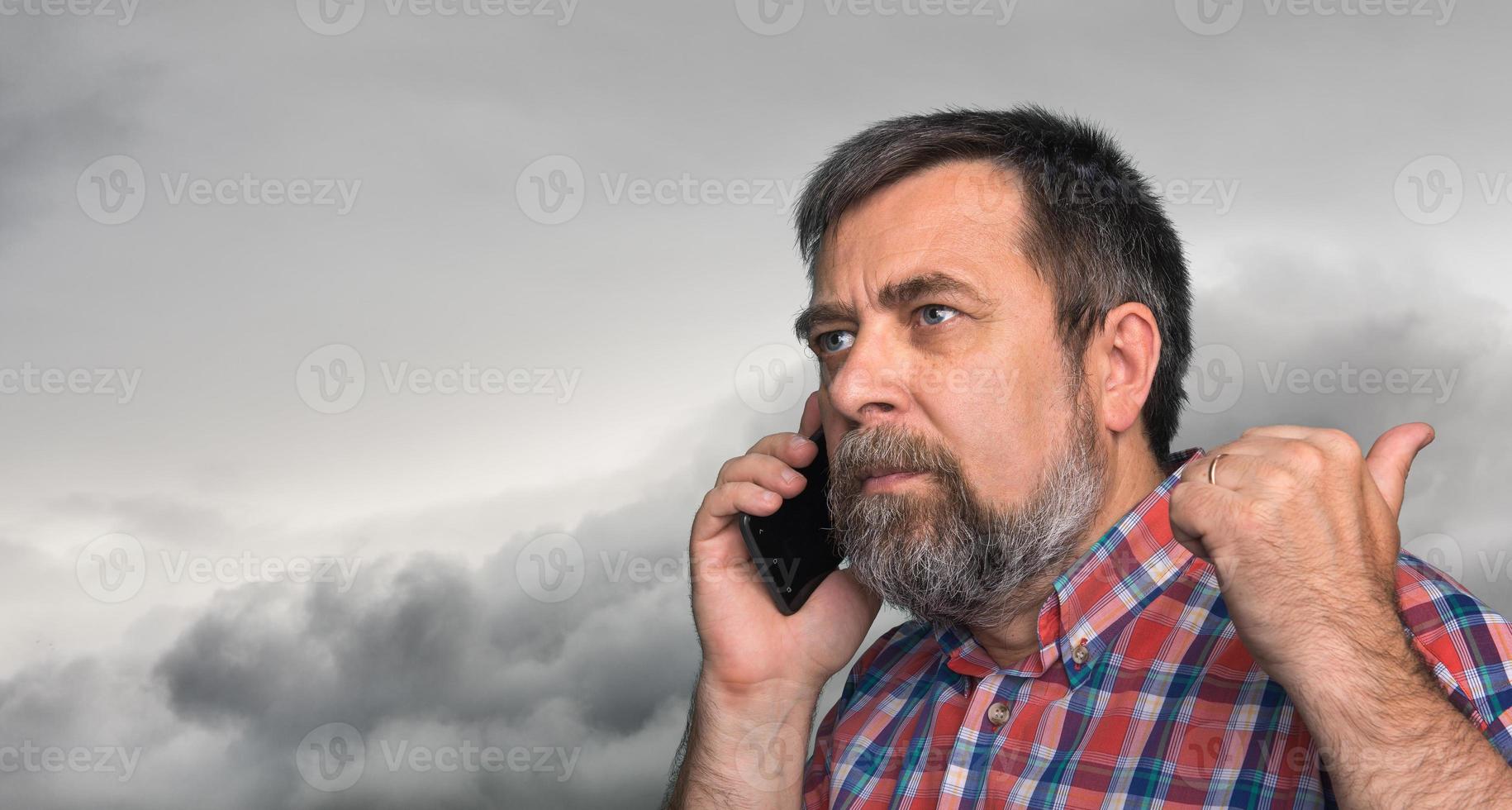 middelbare leeftijd Mens spreekt Aan een mobiel telefoon foto