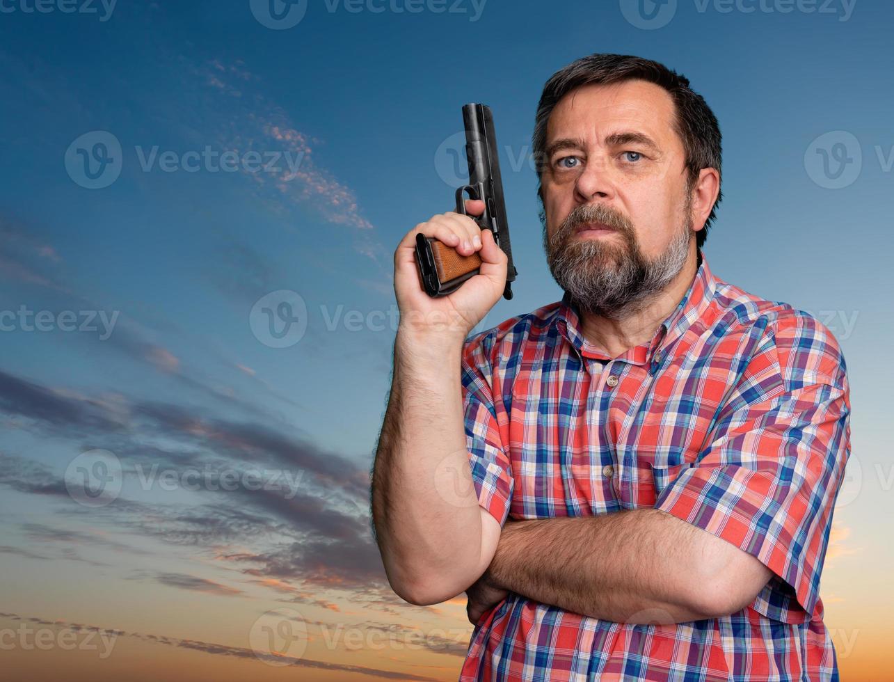 portret van een knap Mens Holding een geweer foto
