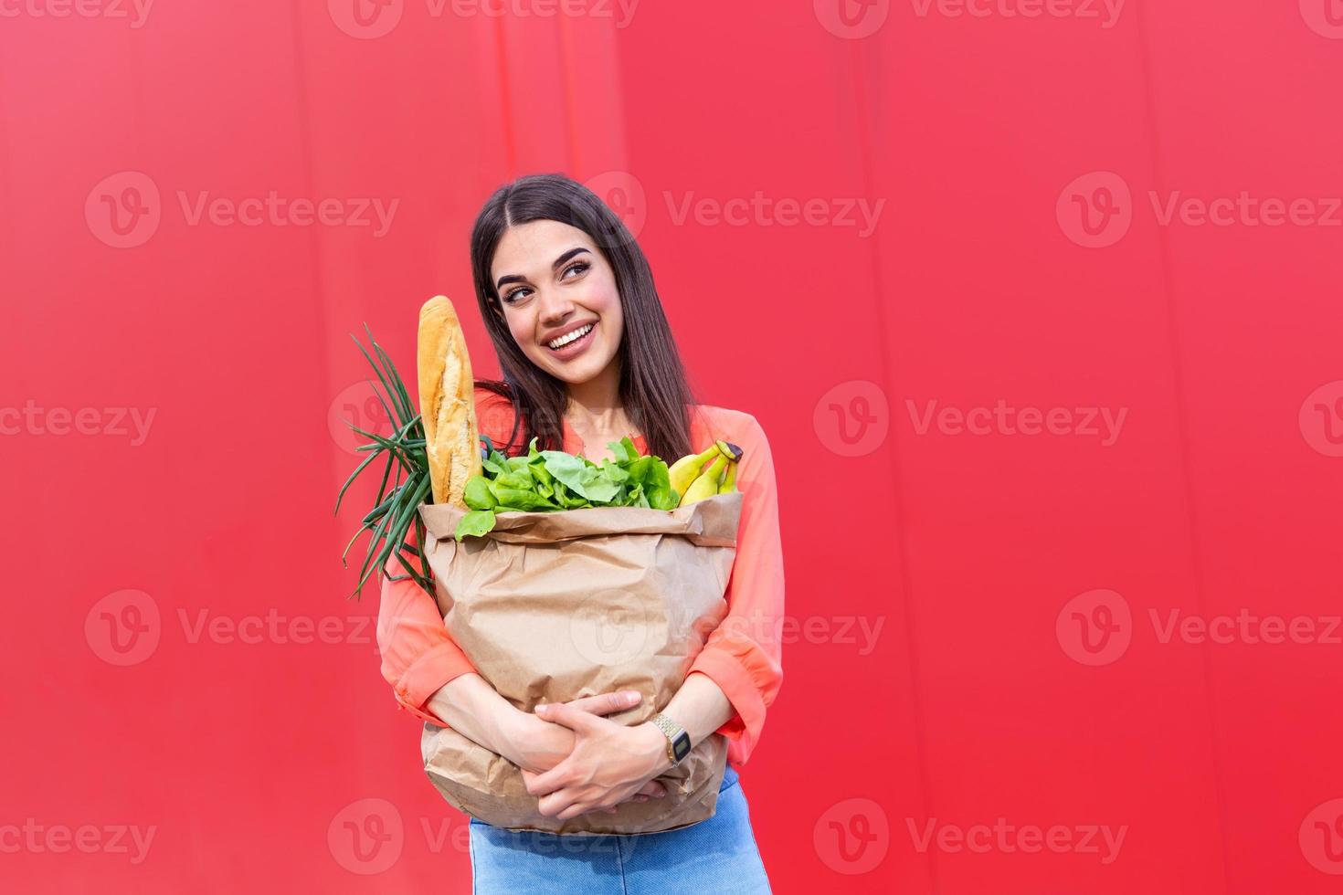 jong vrouw Holding een boodschappen doen zak vol van groenten boodschappen, jong vrouw Holding kruidenier papier boodschappen doen zak vol van vers groenten. vrouw Holding een boodschappen doen zak vol van vers voedsel foto