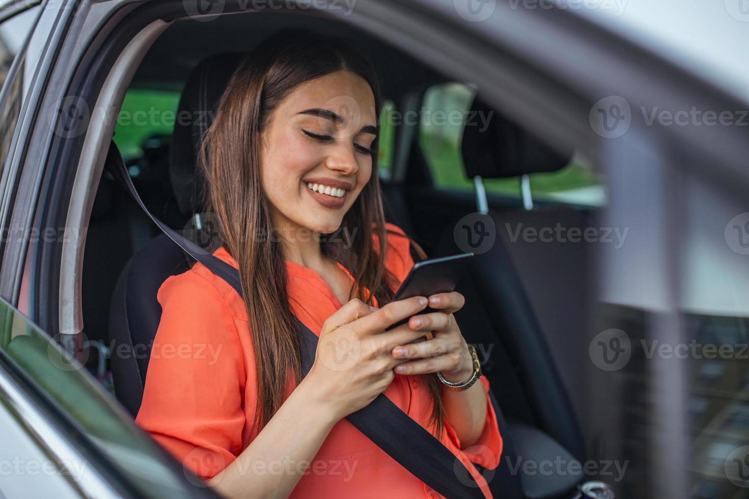 mooi hoor mooi jong vrouw glimlach en gebruik mobiel telefoon aanraken de scherm binnen de auto terwijl reizen. modern concept van zoeken scharnieren en contact vrienden wanneer u zijn weg. dagelijks gebruik van smartphone foto