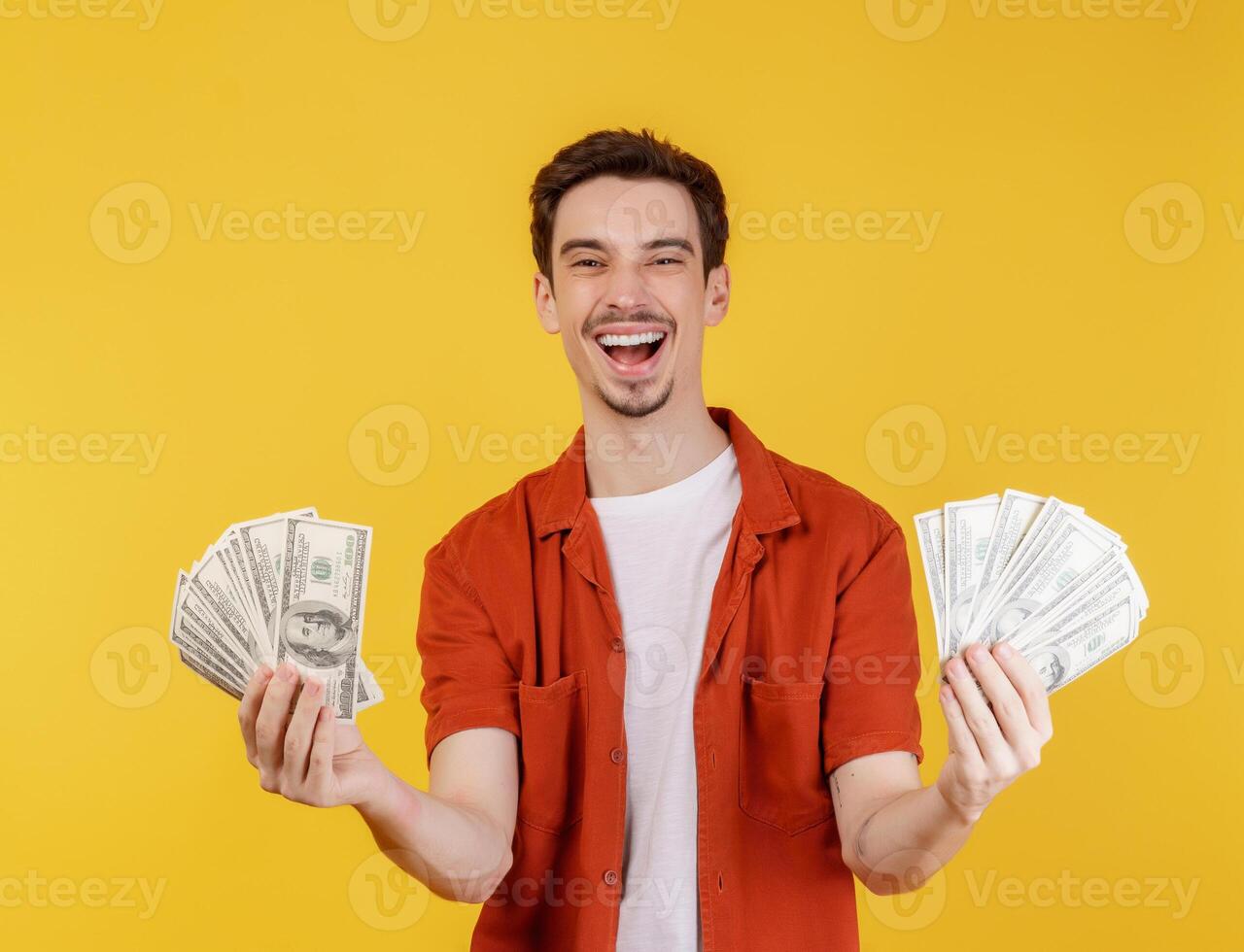 portret van een vrolijk Mens Holding dollar rekeningen over- geel achtergrond foto