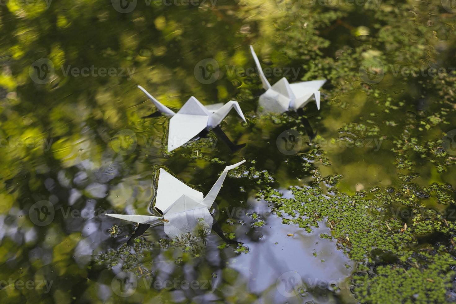 dichtbij omhoog origami kranen drijvend Aan water concept foto