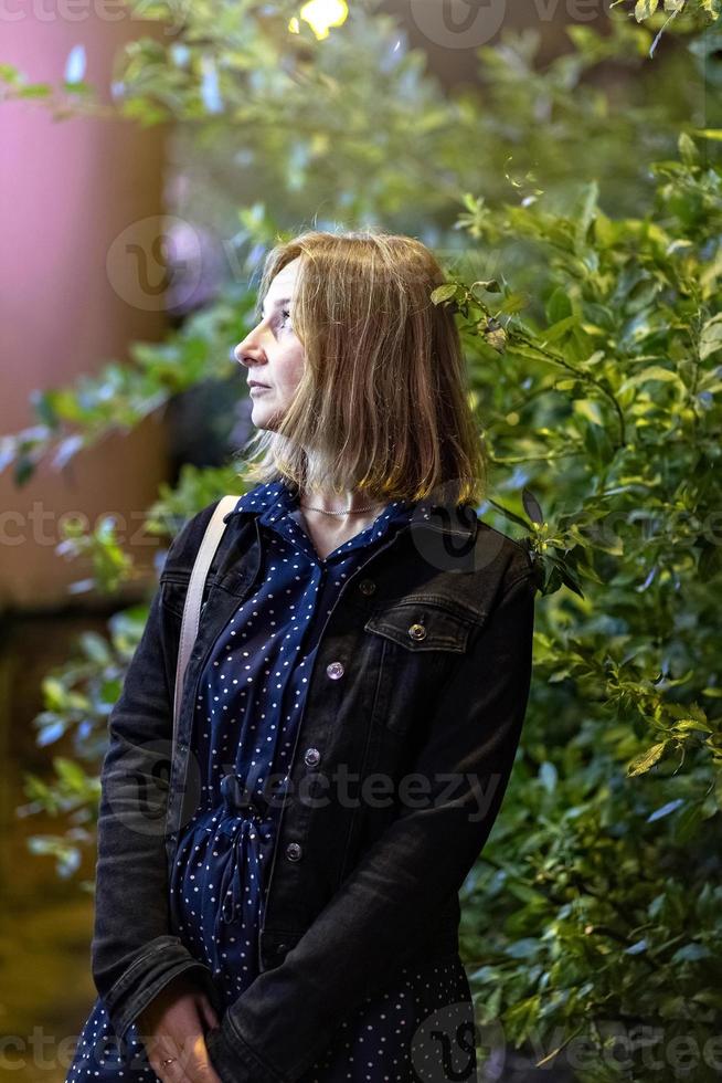 portret van een jong vrouw in een nacht stad Aan een zomer avond. stad lichten foto