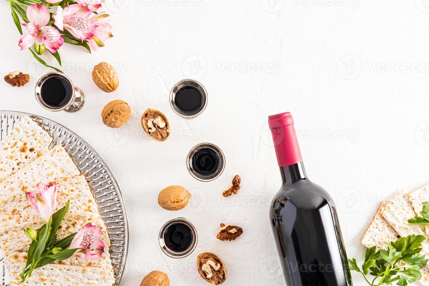 Joods vakantie. pascha. wit achtergrond met zilver bril van rood wijn, feestelijk producten. vlak indeling. foto
