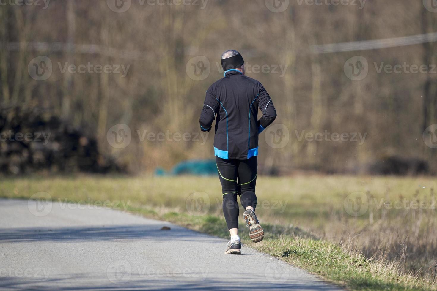 Mens terwijl jogging Aan land weg foto