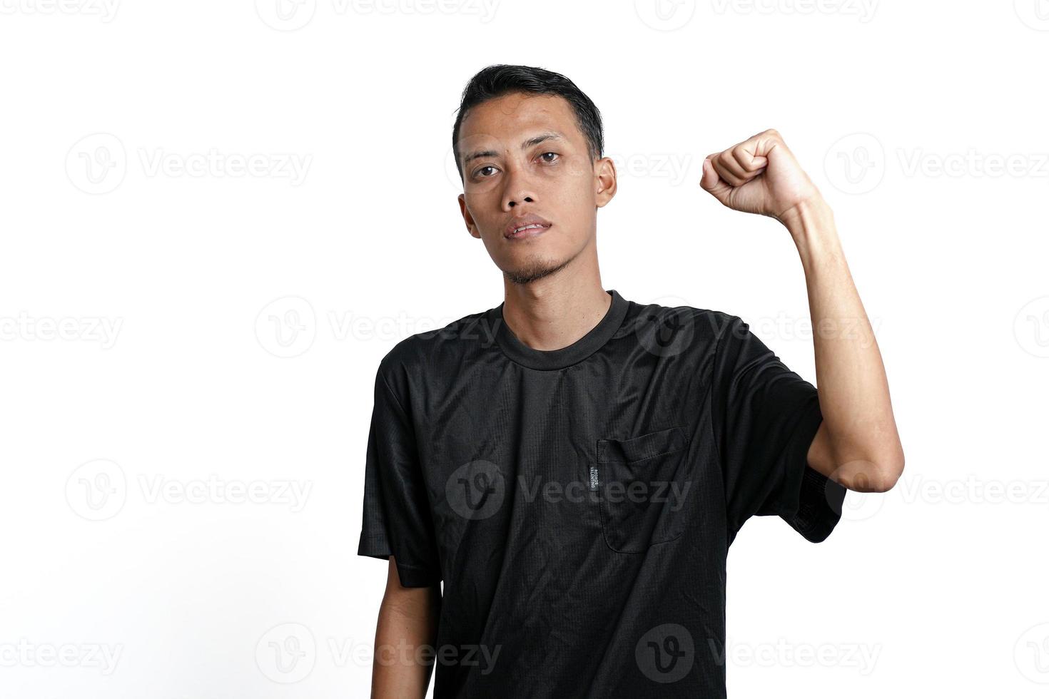 Aziatisch Mens vervelend zwart opleiding t-shirt, tonen een sterk houding met verheven armen en spieren. geïsoleerd door wit achtergrond foto