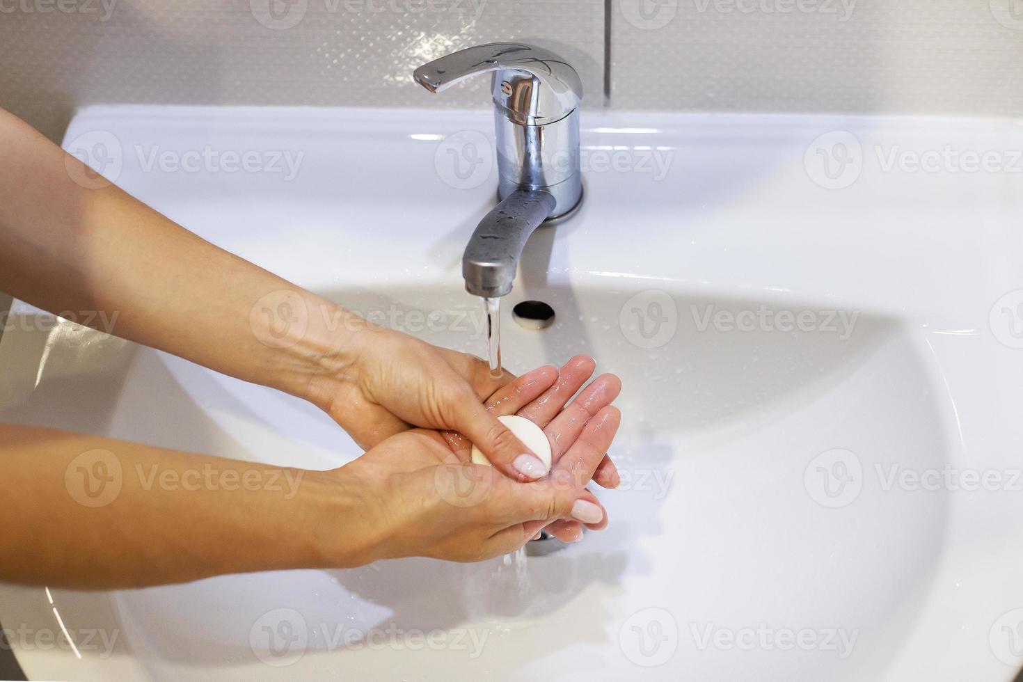 het wassen handen met zeep en water onder de tik, detailopname. dagelijks hygiëne. foto