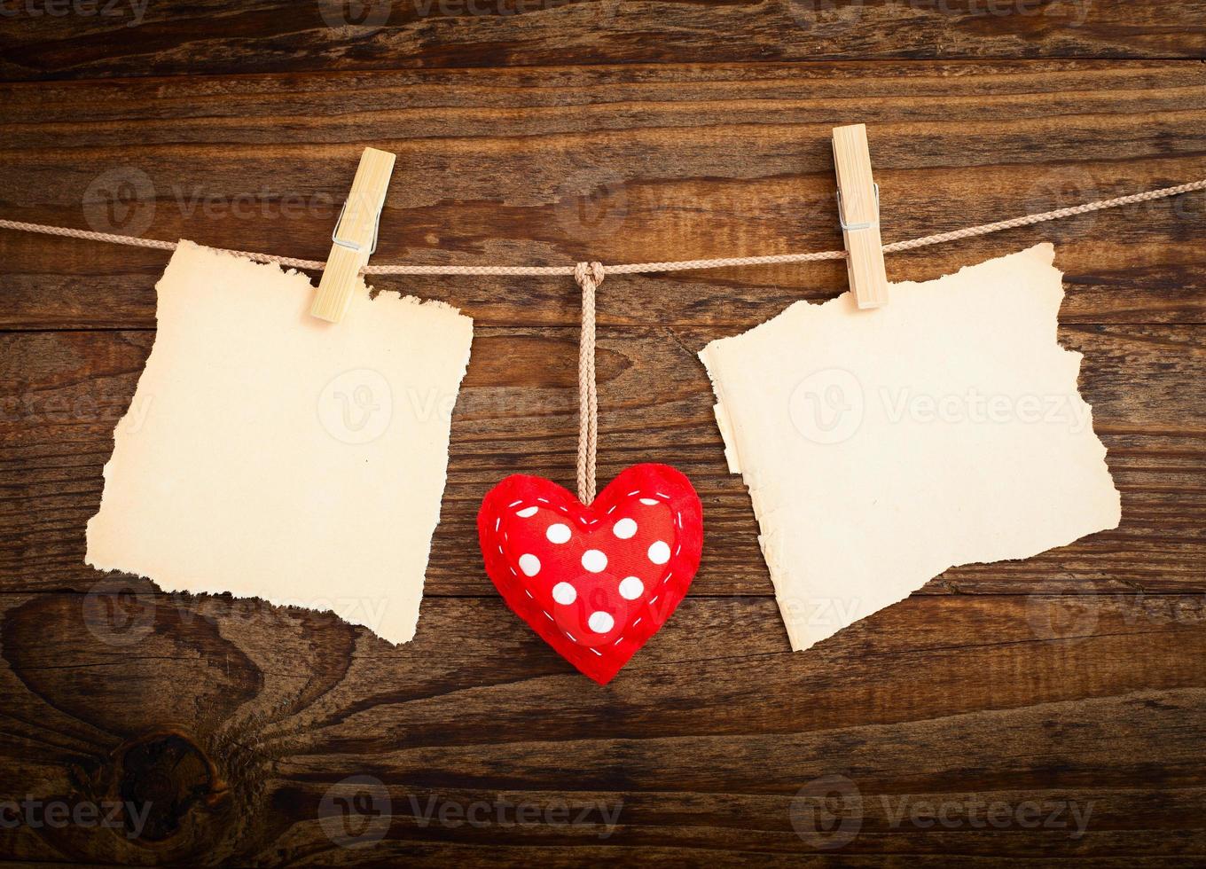 blanco vel, een Opmerking, een gescheurd vel van papier en wijnoogst rood harten hangende Aan guirlande. valentijnsdag dag concept foto
