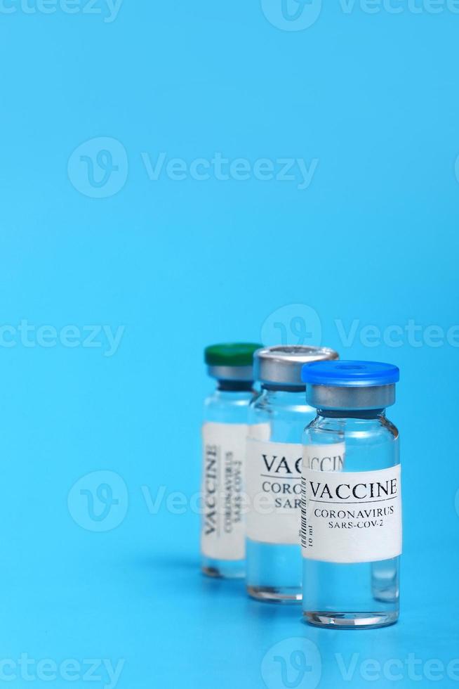 vaccin selectie. ampullen met covid-19 vaccin in laboratorium. naar strijd de coronavirus SARS-CoV-2 pandemie. glas flacon medisch detailopname geïsoleerd Aan een blauw achtergrond. foto