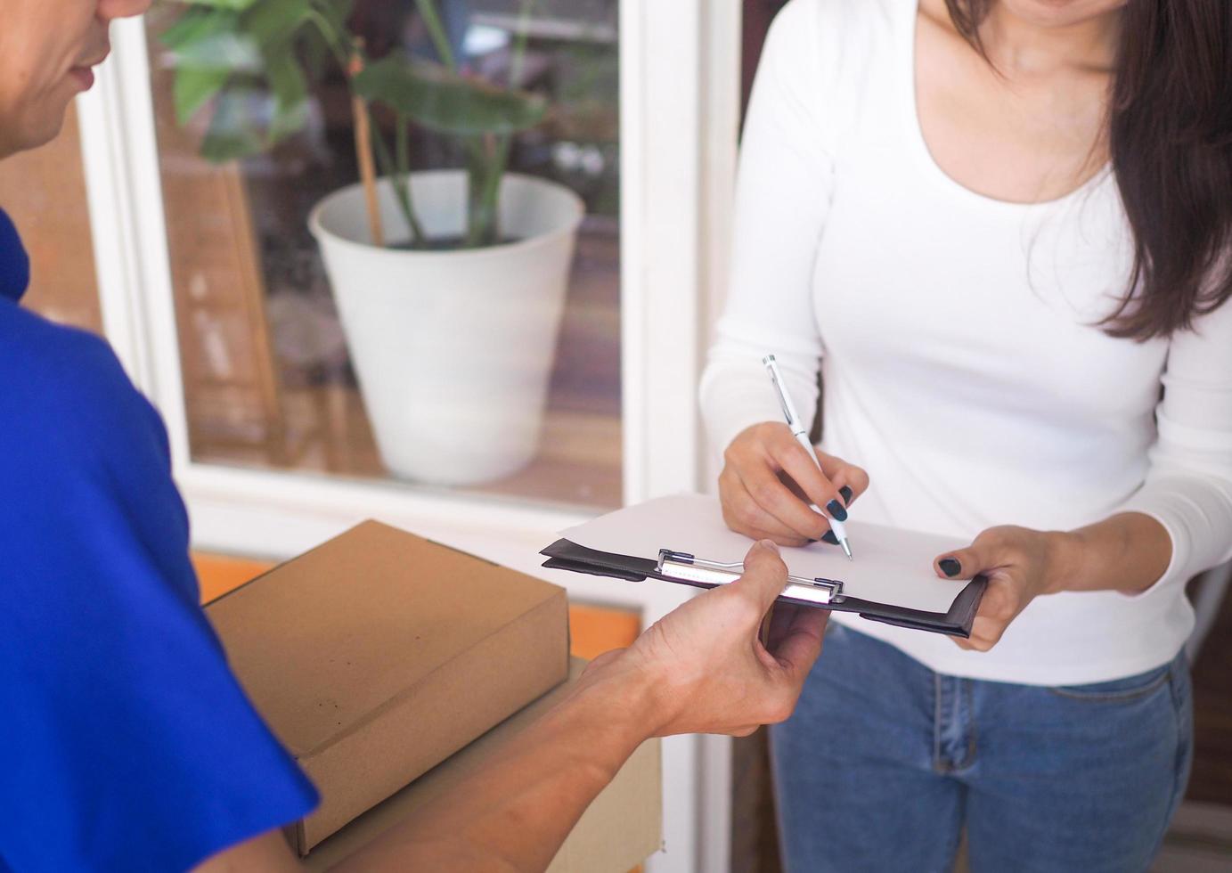 vrouw ondertekening bon van pakket levering. foto