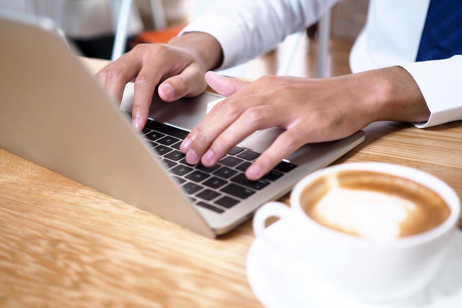 de menselijk hand- toepassingen de toetsenbord door de notitieboekje Aan de bureau. internet onderwijs en communicatie concepten foto