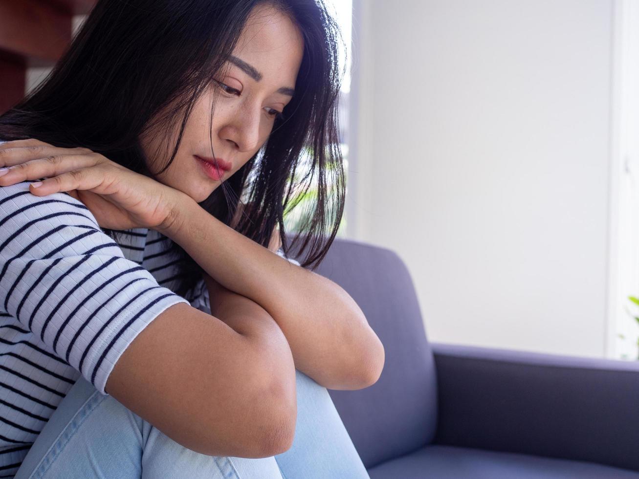Aziatisch Dames zijn gestrest, zittend verontrustend over familie problemen, hartverscheurend en hebben mentaal symptomen. foto