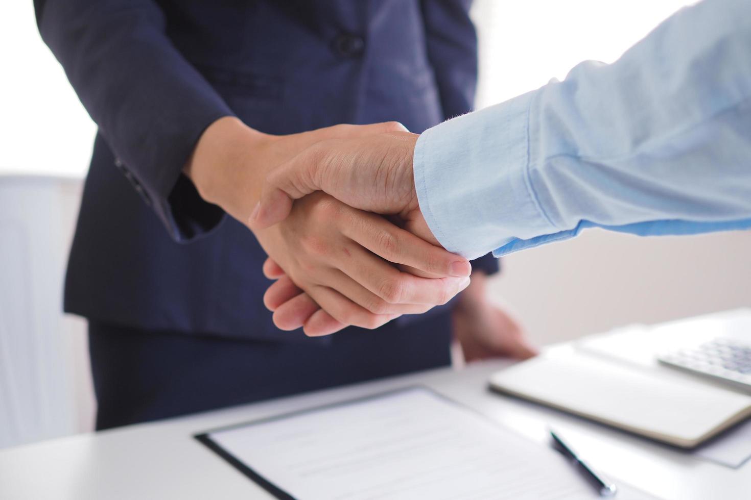 twee zakenlieden schudden handen na onderhandelen de overeenkomst en ondertekening de contract. foto