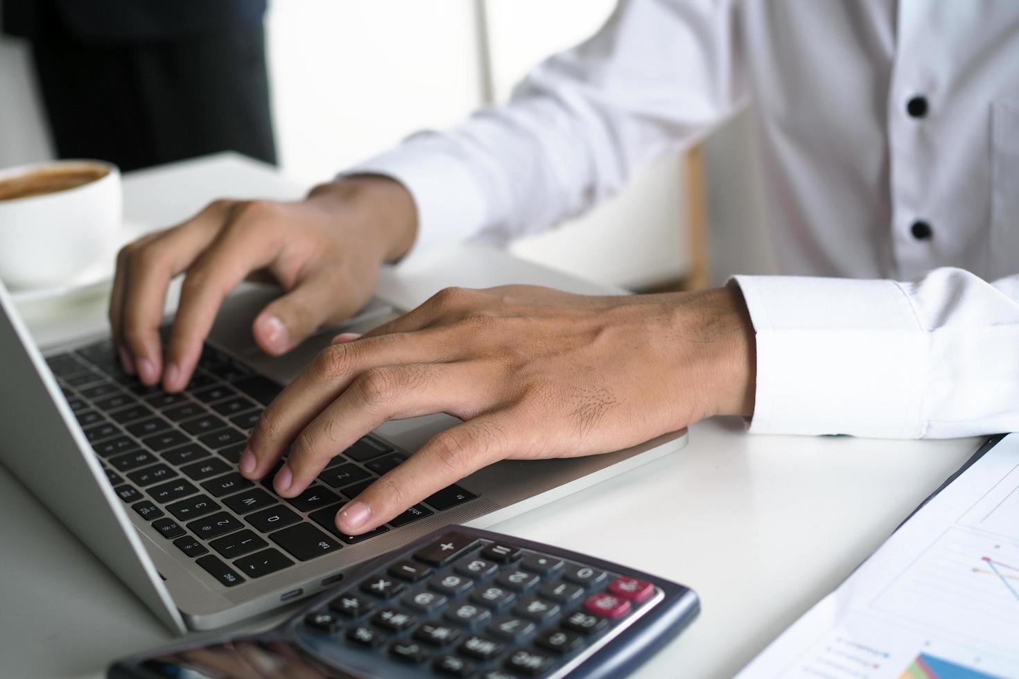 de menselijk hand- toepassingen de toetsenbord door de notitieboekje Aan de bureau. internet onderwijs en communicatie concepten foto