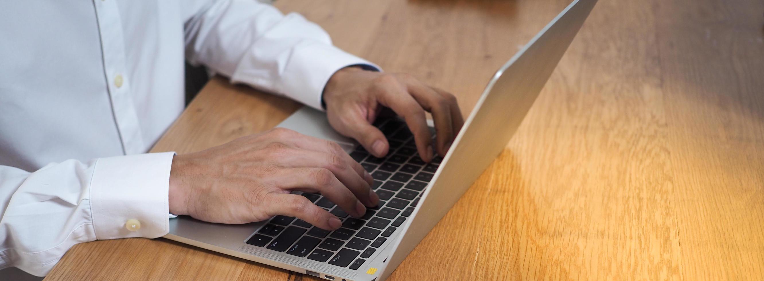 de menselijk hand- toepassingen de toetsenbord door de notitieboekje Aan de bureau. internet onderwijs en communicatie concepten foto