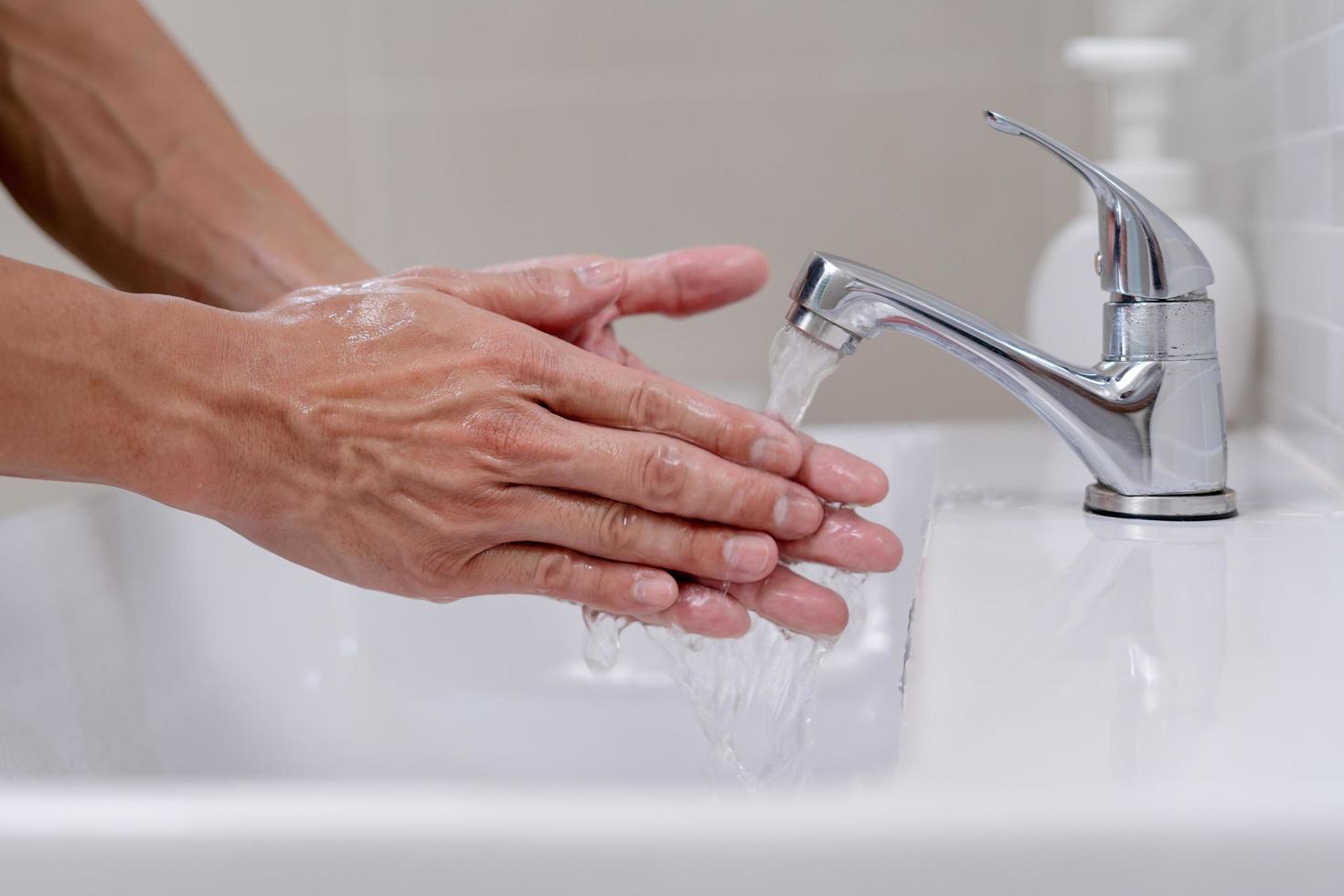 persoon handen wassen met zeep bubbels en spoelen met schoon water naar voorkomen en hou op de verspreiding van bacterieën, virus of covid19. mooi zo Gezondheid en mooi zo hygiëne foto
