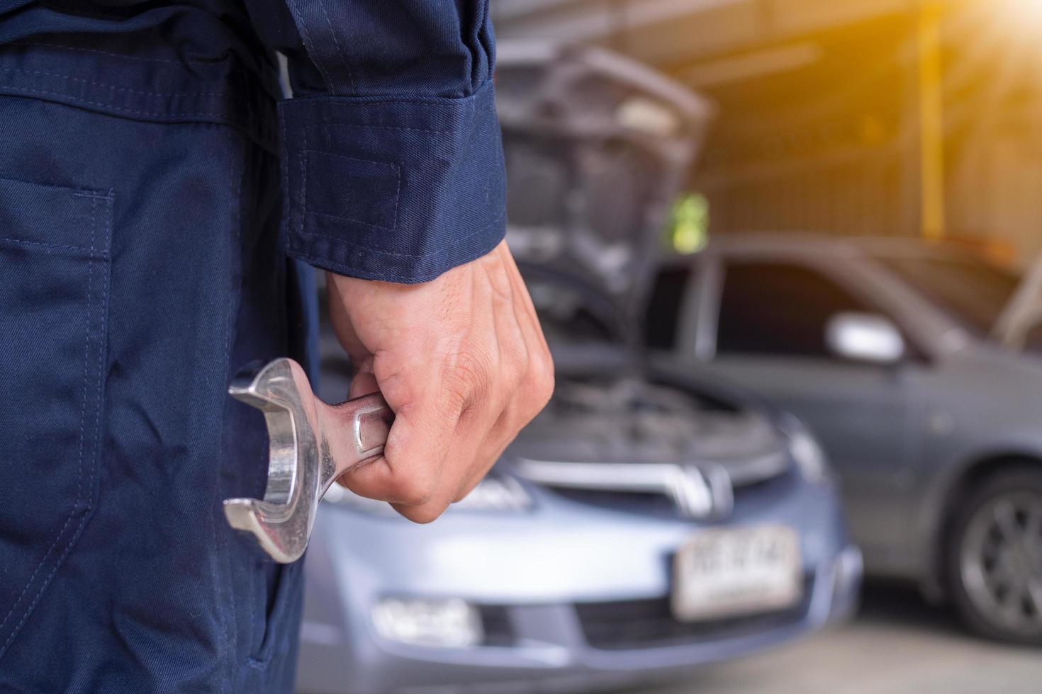 de monteur draagt een uniform en heeft een schroevendraaier. concept van auto onderhoud, reparatie, onderhoud, klaar naar onderhoud foto