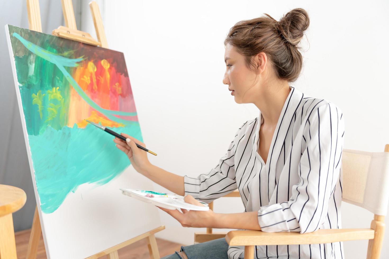 professioneel vrouw artiest meisje gebruik penseel in abstract kunst voor creëren meesterwerk. schilder verf met aquarellen of olie in studio huis. mooi vrouw genieten schilderij net zo hobby. werk recreatie foto