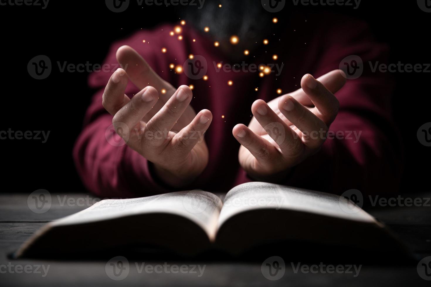 handen gevouwen in gebed Aan een heilig Bijbel in kerk concept voor vertrouwen, geestelijkheid en geloof, Mens bidden in ochtend. Mens hand- met Bijbel bidden. persoon christen wie geloof in Jezus aanbidden in donker. foto