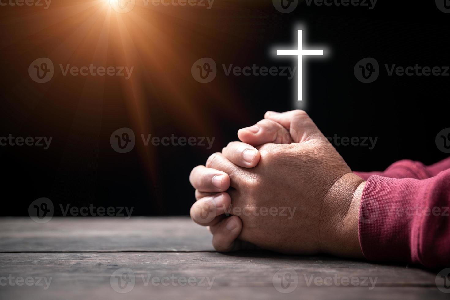 handen gevouwen in gebed Aan heilig Bijbel met kruis in kerk concept voor vertrouwen, geestelijkheid en geloof, Mens bidden Aan heilig Bijbel met kruisbeeld in ochtend. Mens hand- met Bijbel en roede bidden naar god. foto