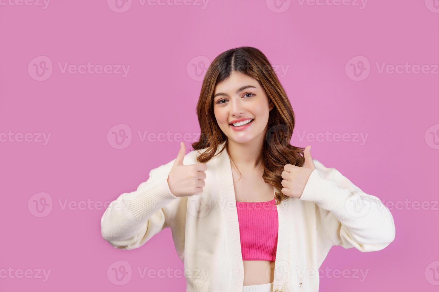 portret van jong gelukkig vrolijk vrouw tonen duim omhoog en op zoek Bij camera geïsoleerd over- roze achtergrond foto