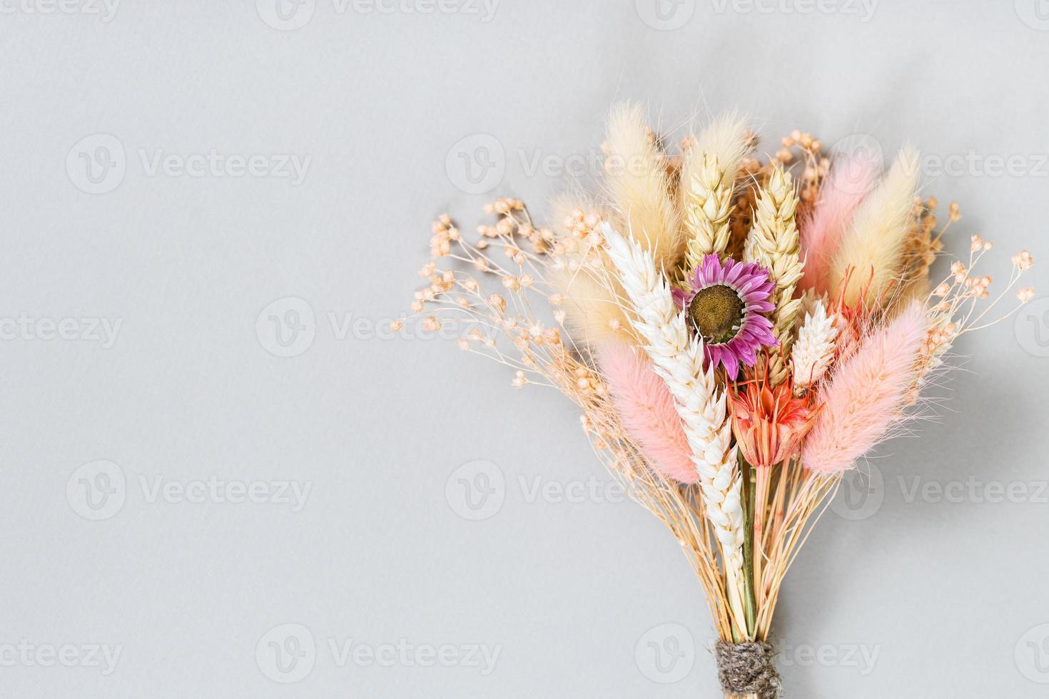 gebonden boeket van droog bloem en aartjes Aan grijs foto