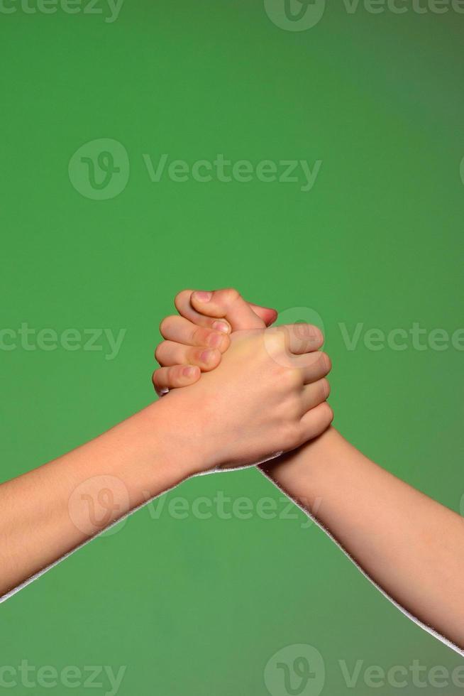 twee handen handdruk, geïsoleerd Aan een groen achtergrond, symboliseert vriendschap en verzoening foto