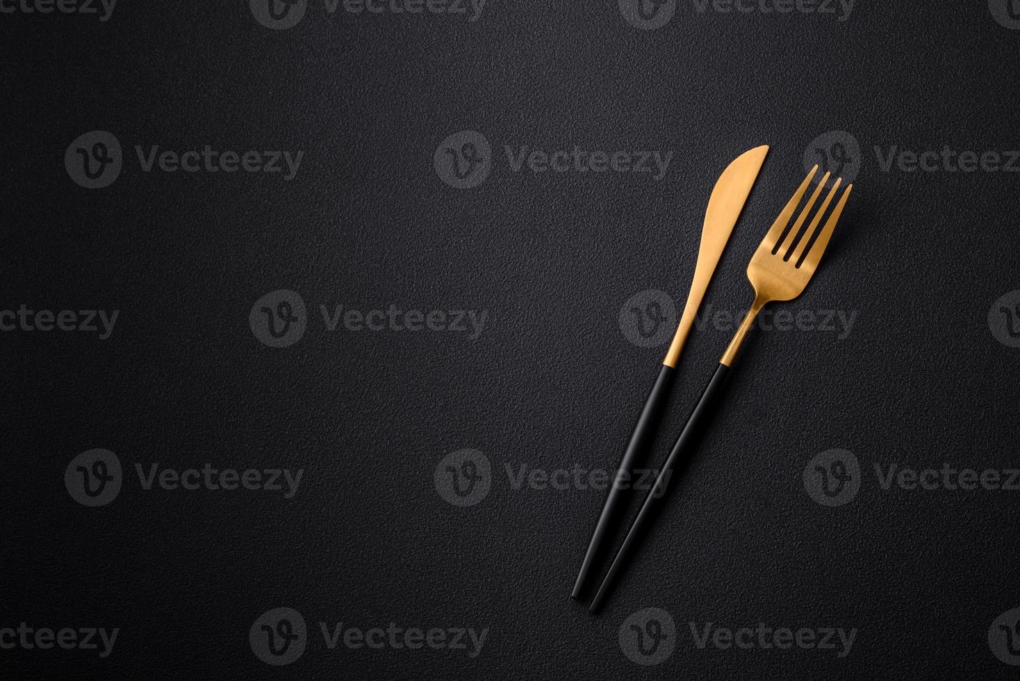 metaal keuken mes en vork Aan een donker getextureerde beton achtergrond foto