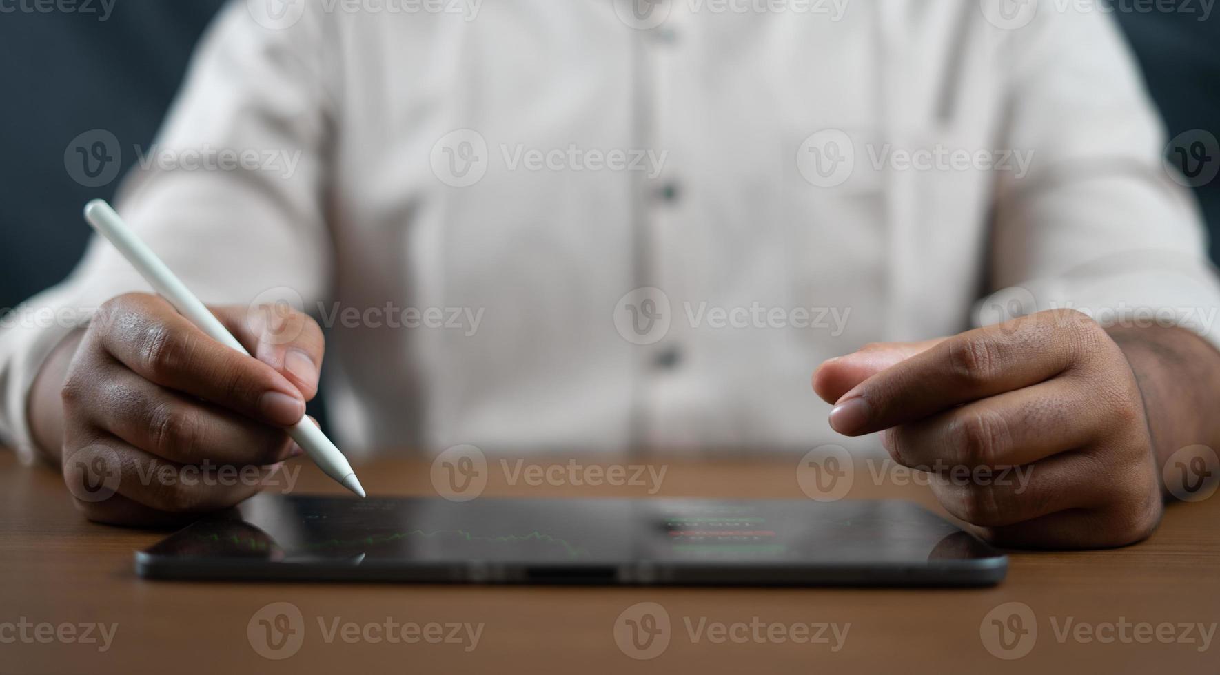 Mens Holding een digitaal potlood en schrijven Aan een tablet voor een technologie bedrijf concept foto