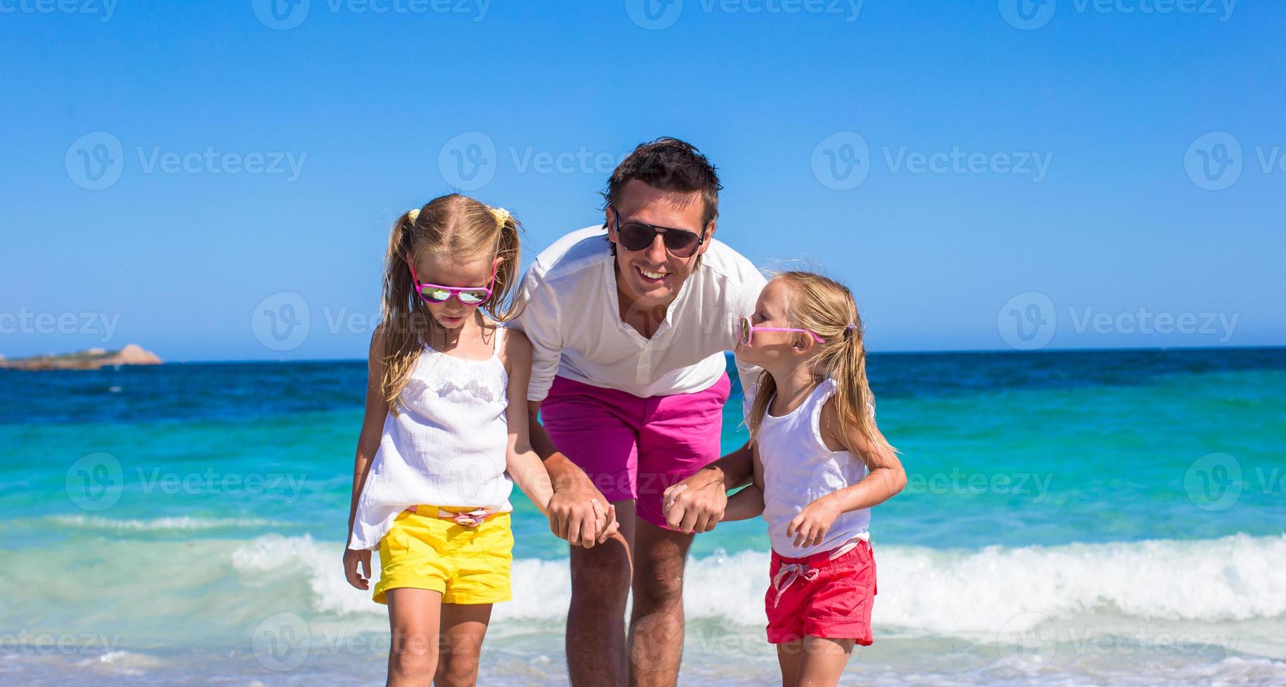 weinig meisjes en gelukkig vader hebben pret gedurende tropisch vakantie foto