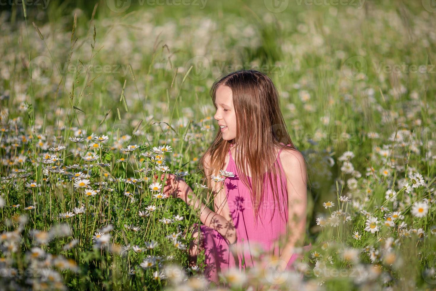 gelukkig kind in veld. mooi meisje in jurk in een rietje hoed foto