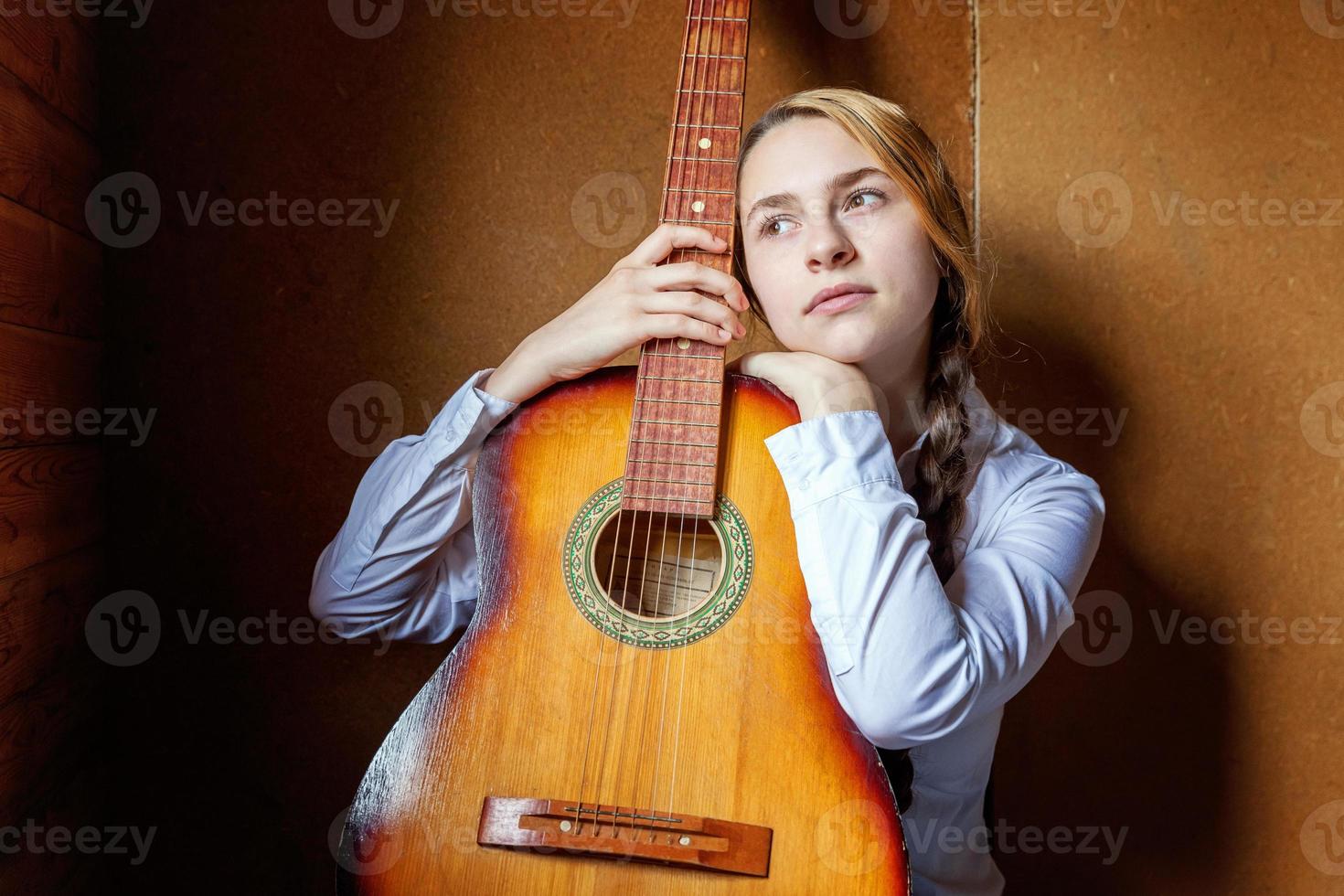 jong hipster vrouw zittend Aan verdieping en spelen gitaar Bij huis. tiener meisje aan het leren naar Speel lied en schrijven muziek- in haar kamer. hobby, levensstijl, kom tot rust, instrument, vrije tijd, onderwijs concept. foto