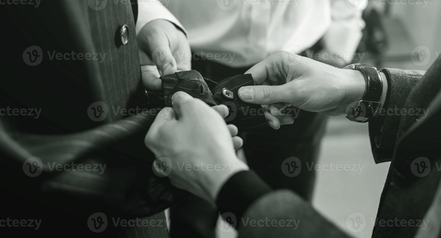 kleermaker controle de kwaliteit van de pak kleding stof foto