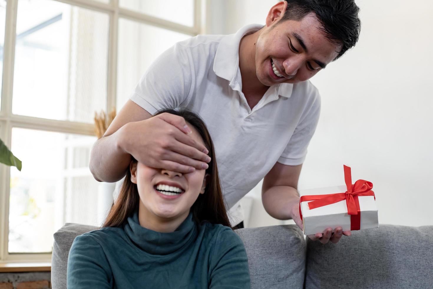 man verrast zijn vriendin met geschenkdoos. foto