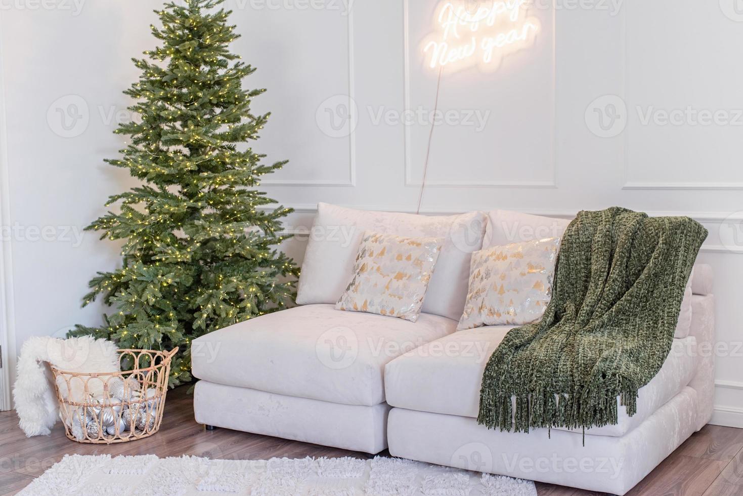 Kerstmis boom met presenteert en lichten en sofa in licht en luchtig leven kamer foto