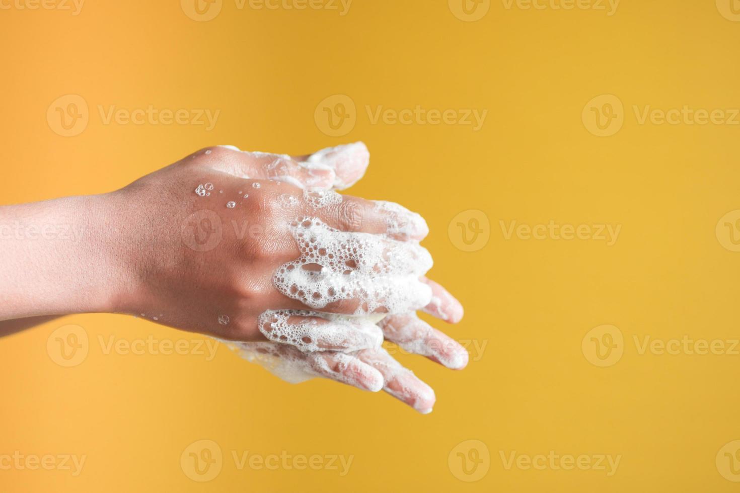 jonge man handen wassen met zeep warm water foto