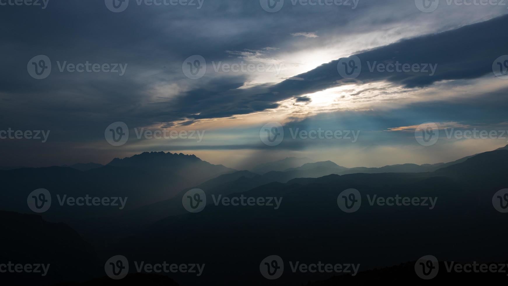 berg landschap met zonnestralen breken door de wolken foto