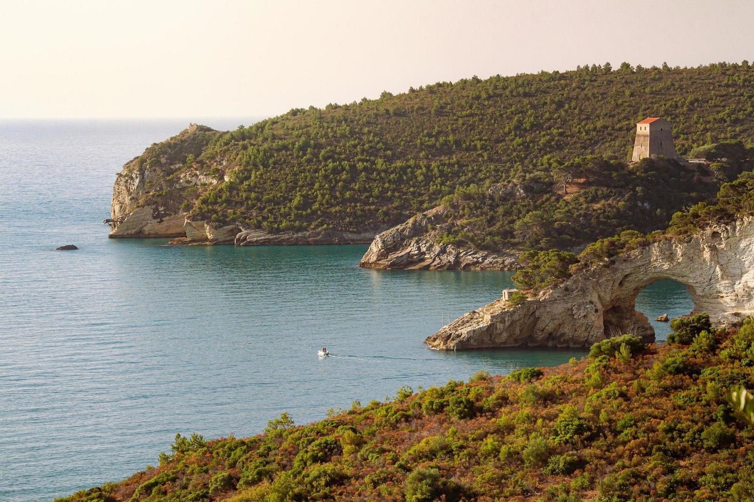 zonsopkomst visie naar boog van san felice - een van nature gevormd kalksteen boog arco e torre di san felice in de buurt stad van vies, mistig, Italië foto