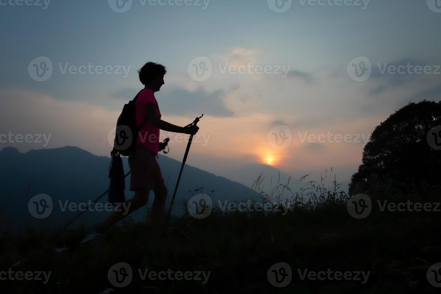 meisje gedurende een zonsondergang avond trektocht in de heuvels foto