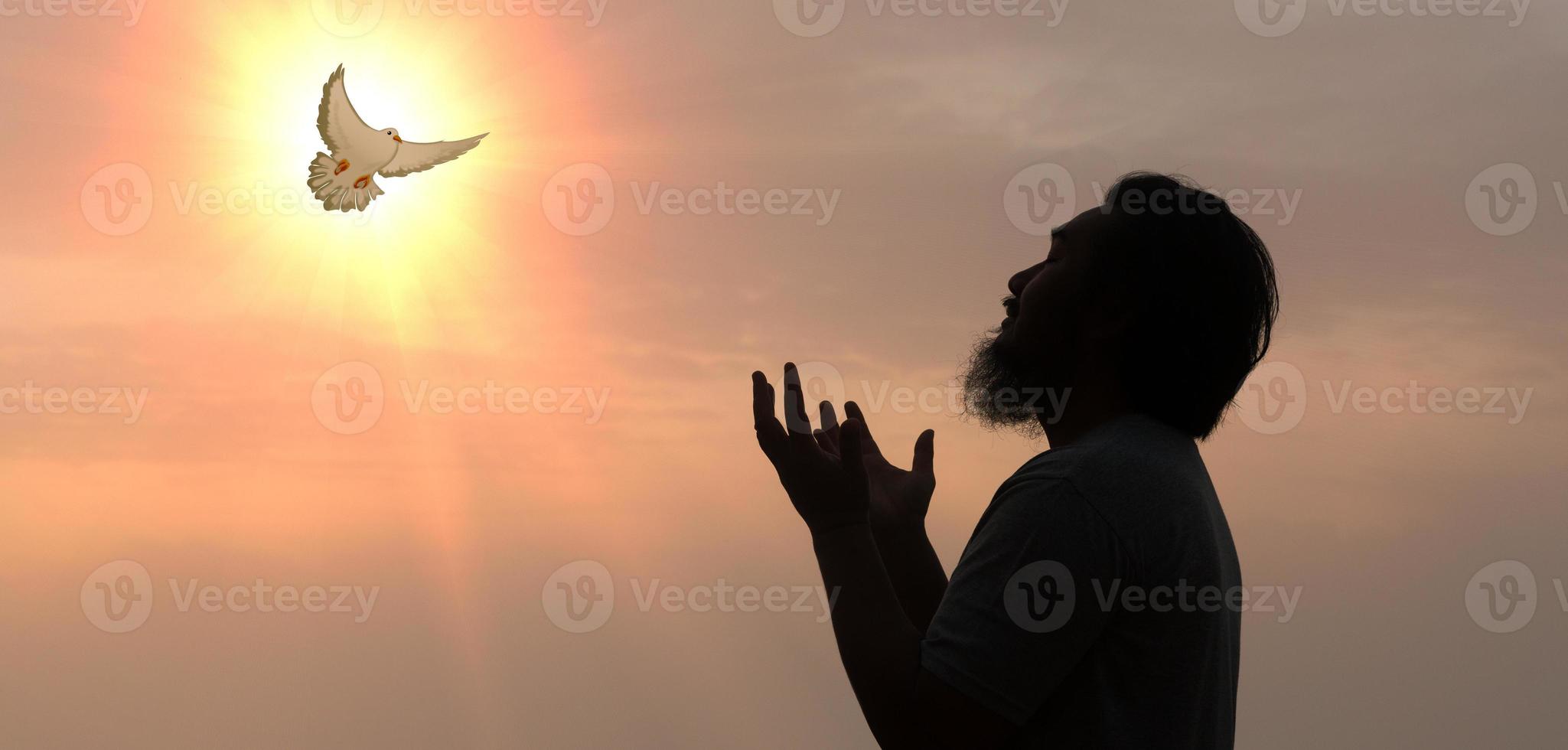 duiven vlieg in de lucht. christenen hebben geloof in heilig geest. silhouet aanbidden naar god met liefde vertrouwen, geest en Jezus Christus. christen bidden voor vrede. concept van aanbidden in Christendom. foto