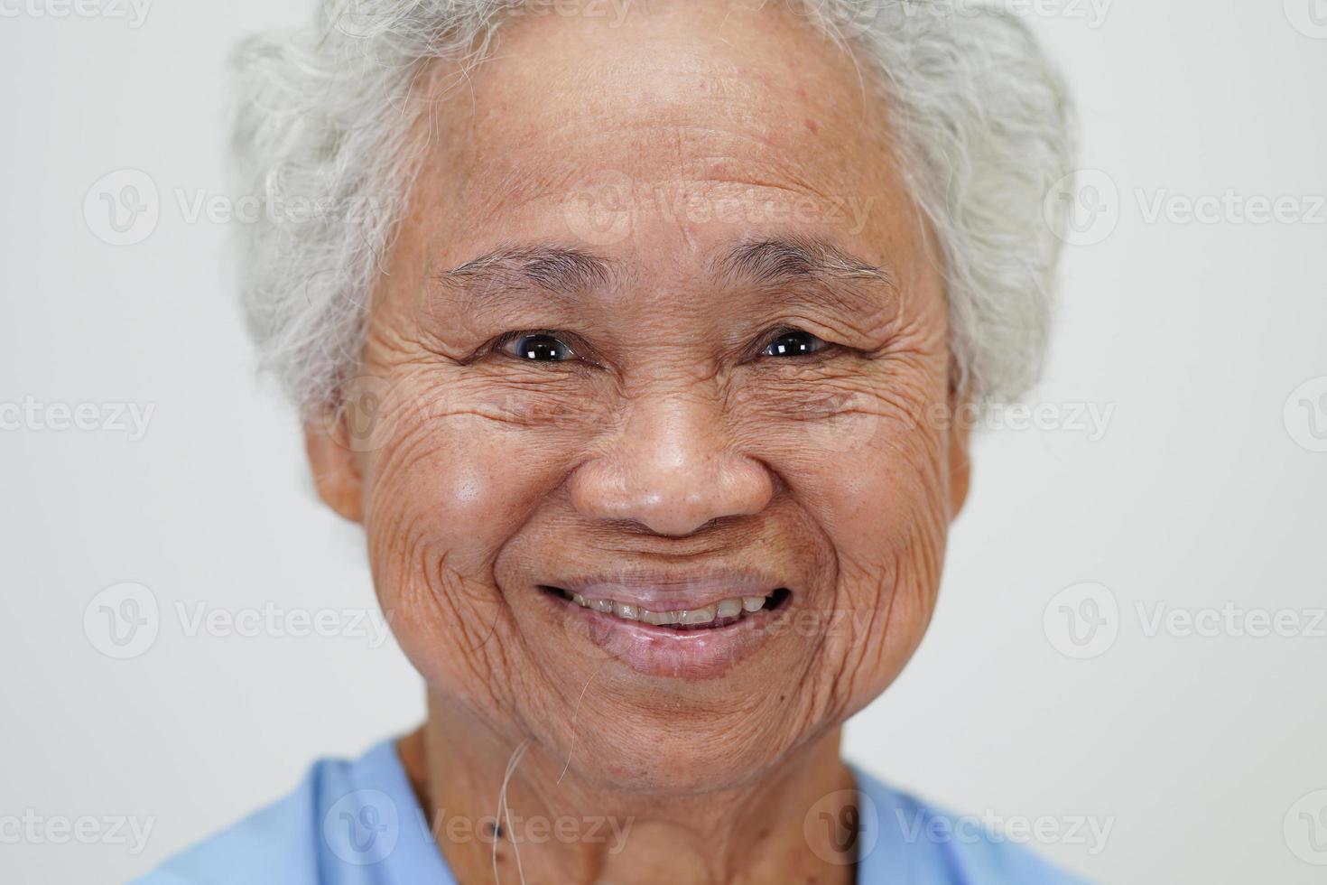 Aziatische oudere senior vrouw patiënt zitten en glimlach gezicht met blij op bed in het ziekenhuis. foto