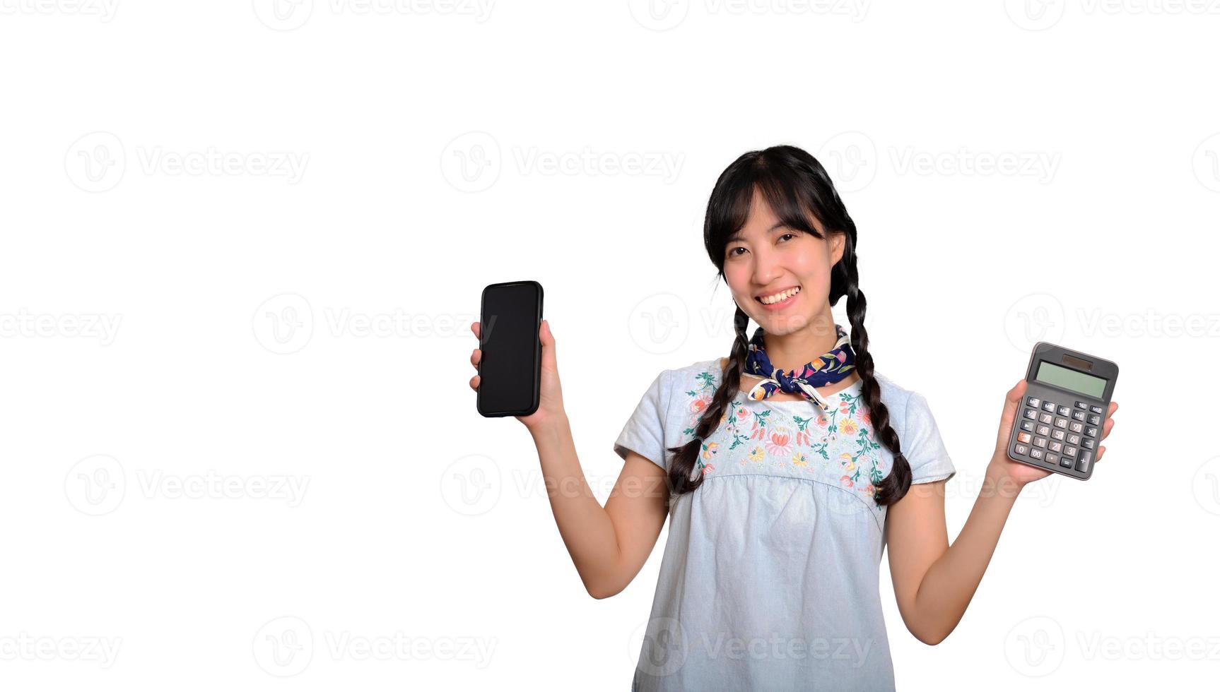 portret van mooi jong Aziatisch vrouw in denim jurk Holding rekenmachine en smartphone Aan wit achtergrond. bedrijf boodschappen doen online concept. foto